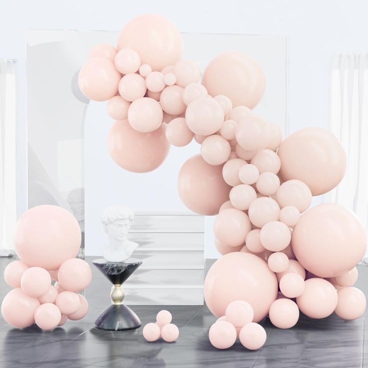 pink balloons are floating in the air near a vase and other items on a table