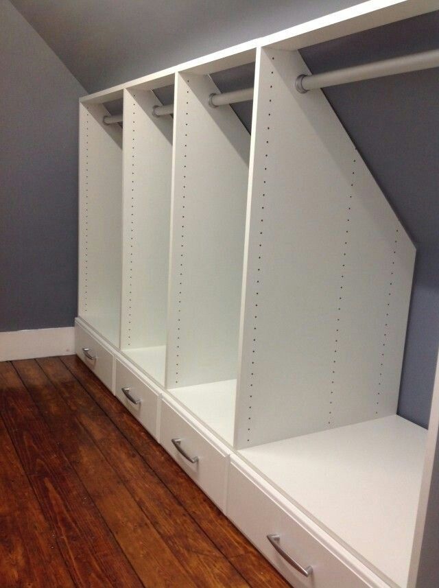 an empty closet with white shelves and drawers