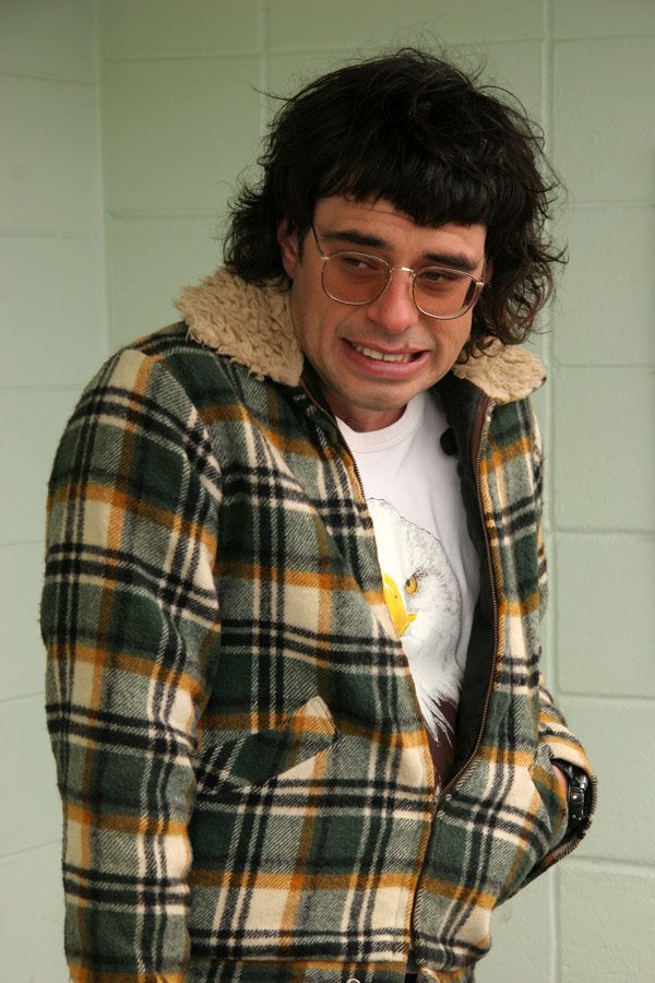 a man wearing glasses and a plaid jacket