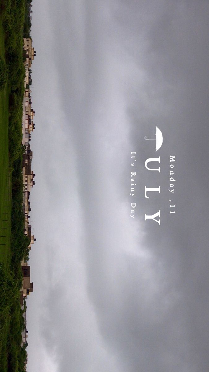 an airplane flying in the cloudy sky over a field