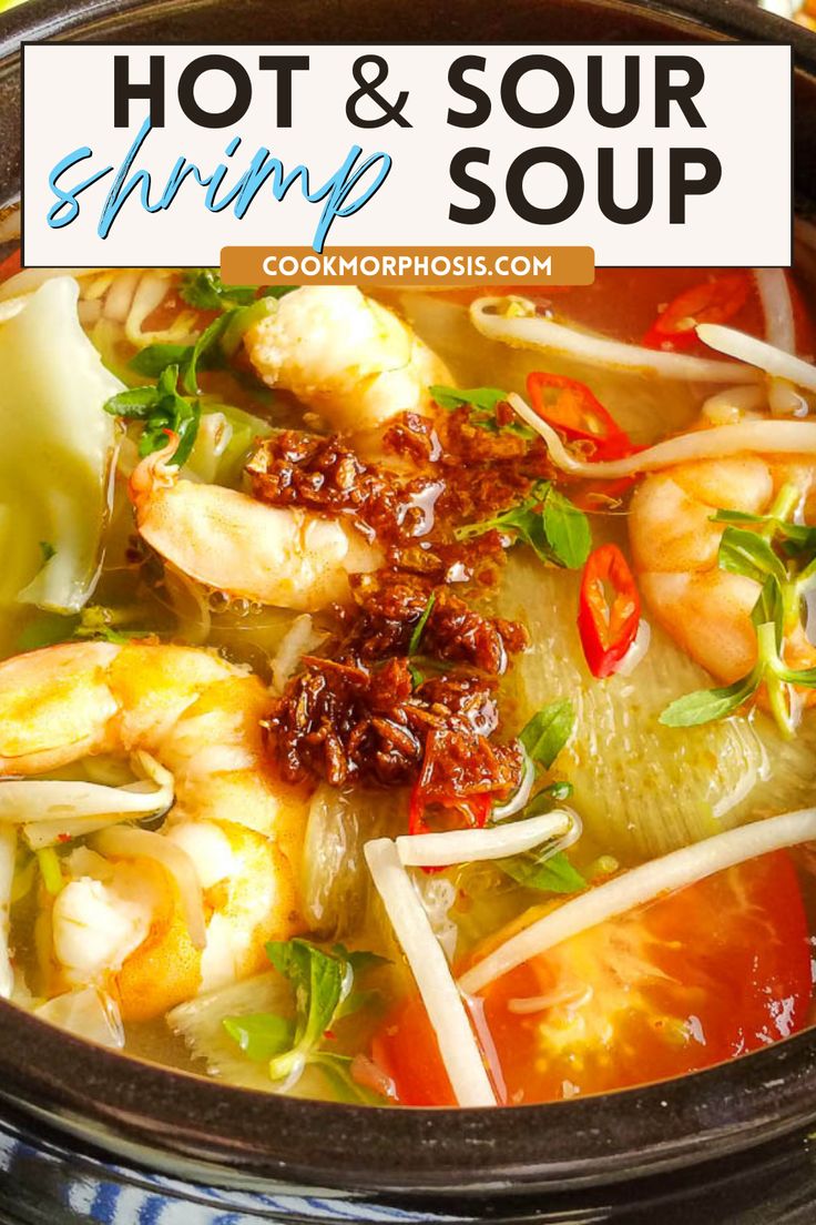 a bowl filled with shrimp, carrots and other vegetables next to a cup of soup