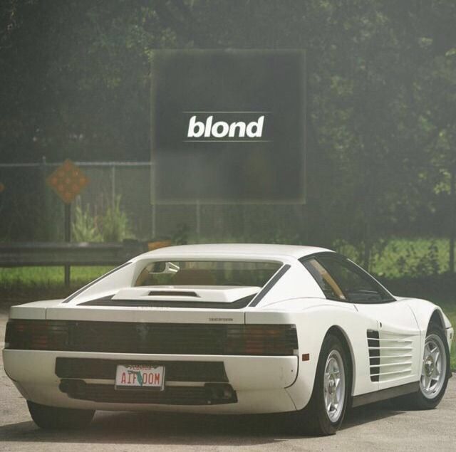 a white sports car is parked in front of a sign that reads blond on it