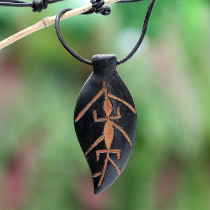 Ralph Ashong translates his ecological concerns into a necklace of masculine elegance. The flora and fauna must be protected by respecting the laws of nature and the environment lest they fall in danger of extinction advices the Ghanaian designer. Hand-carved in the shape of a leaf the teakwood pendant features a gecko colored with a clay solution. The pendant centers an adjustable leather cord. Natural Carved Necklaces As Gift, Traditional Natural Color Necklace For Gift, Traditional Necklace As A Gift, Adjustable Carved Natural Color Necklaces, Adjustable Natural Color Carved Necklaces, Natural Carved Nature-inspired Necklace, Nature-inspired Carved Natural Necklace, Fair Trade Pendant Necklace As A Gift, Fair Trade Brown Necklace For Gift