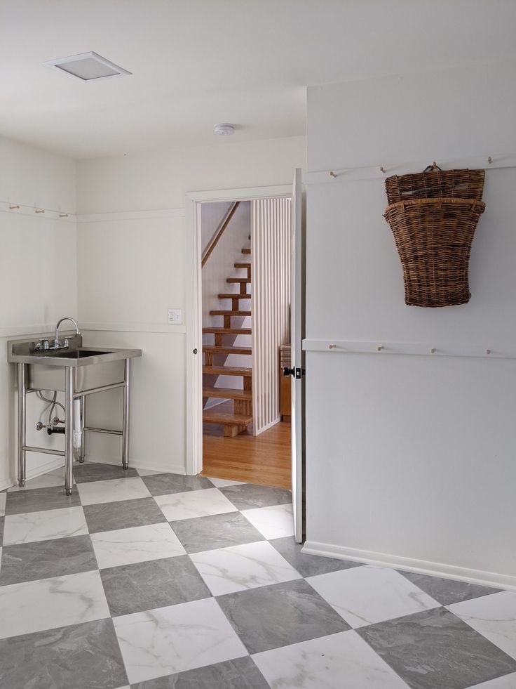 a kitchen with a checkered floor and white walls