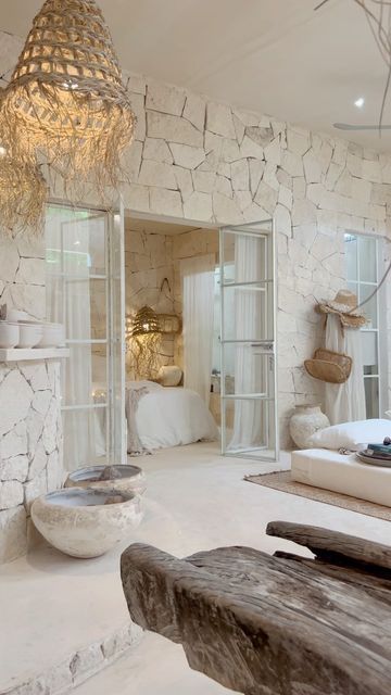 a bedroom with stone walls and white furniture