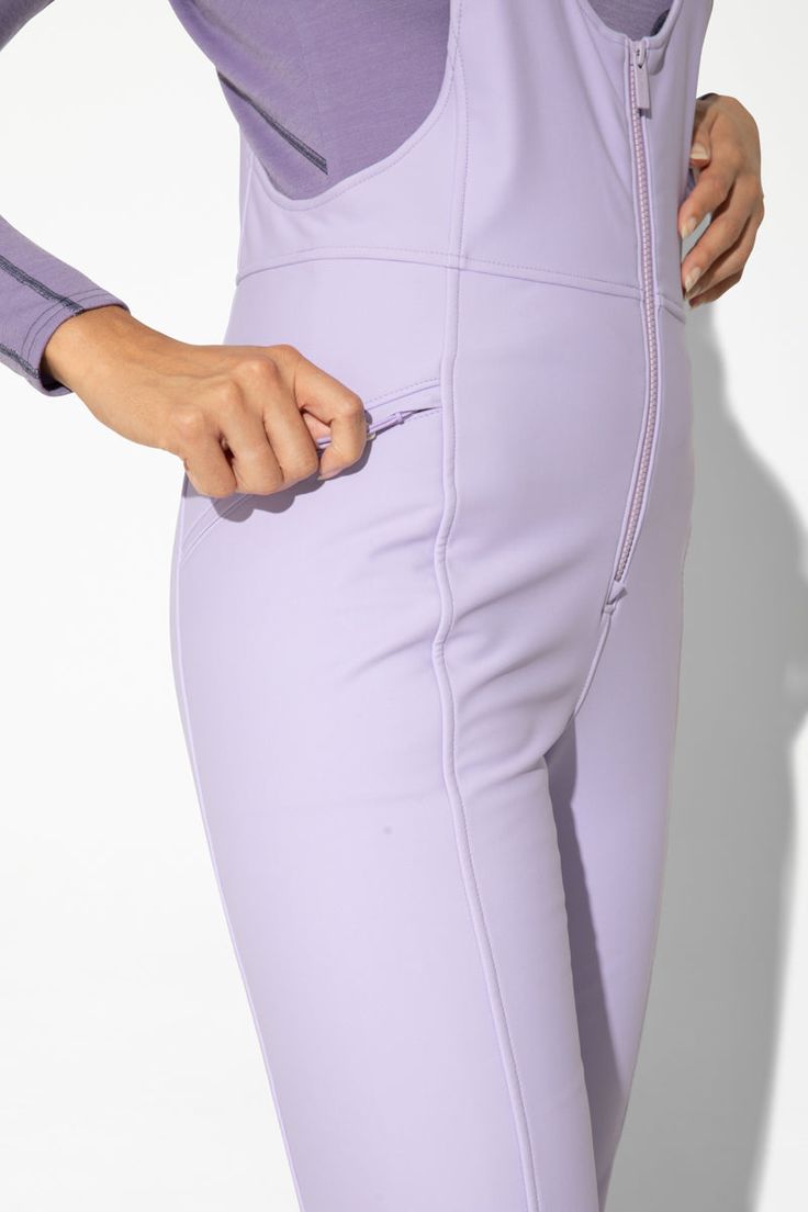 a woman in tight purple pants with her hands on her hip