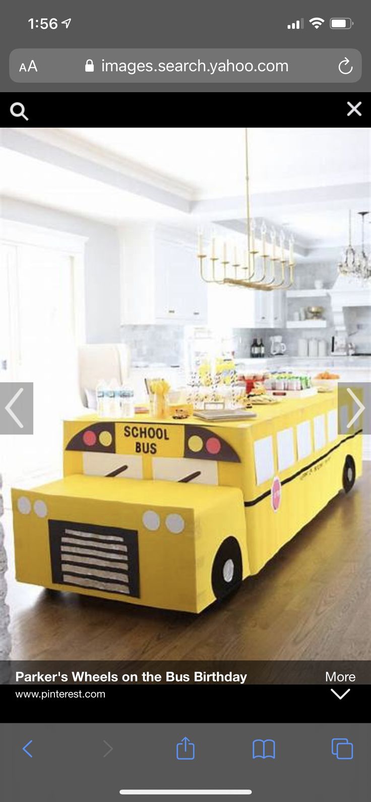 a yellow school bus birthday cake in the middle of a room with white walls and wood floors