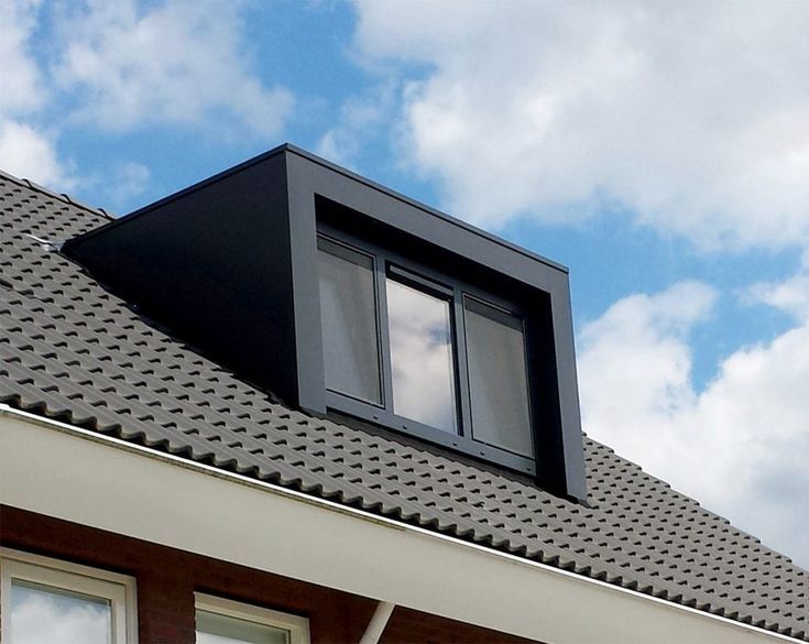 the roof of a house with a window and sky in the backgrouds