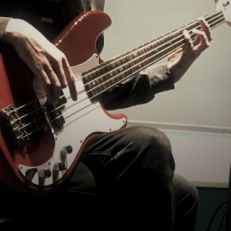 a man is playing an electric bass guitar