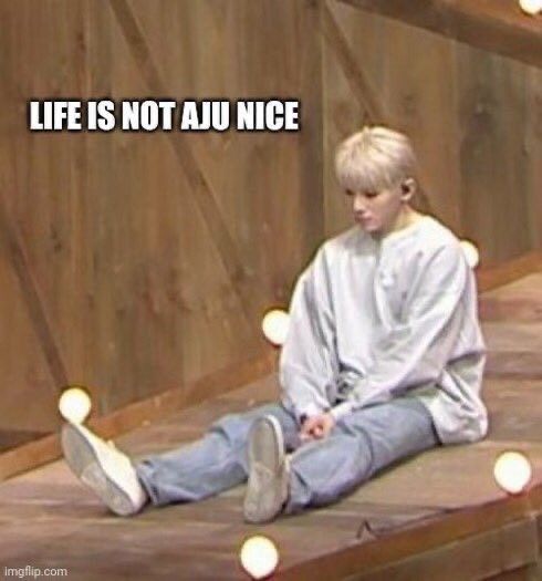 a young boy sitting on the ground with his feet up