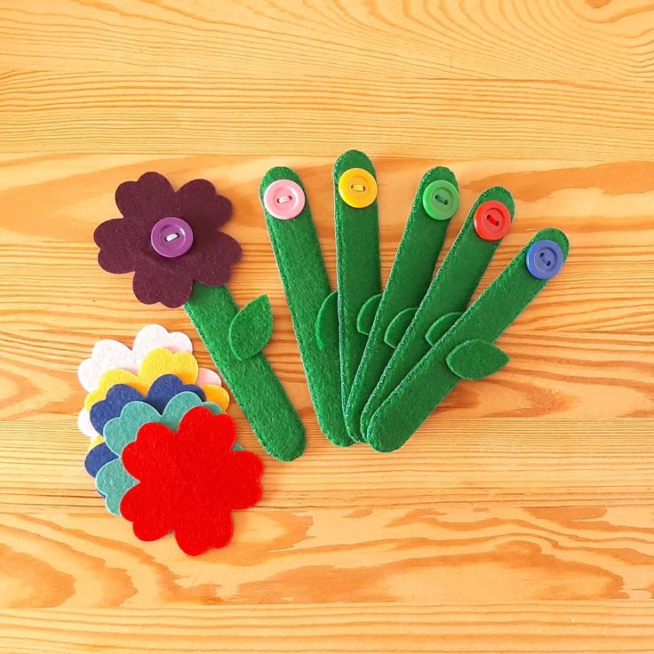 felt flowers and buttons laid out on a wooden surface