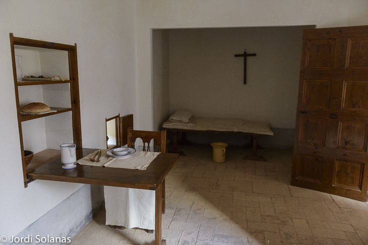 an empty room with a cross on the wall and other items sitting on the floor