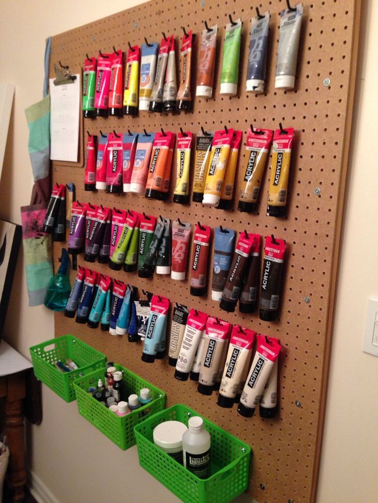 a pegboard with many different types of items hanging on it's sides and two green bins in front of them