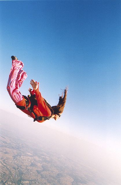 a man flying through the air on top of a snow covered ski slope with his feet in the air