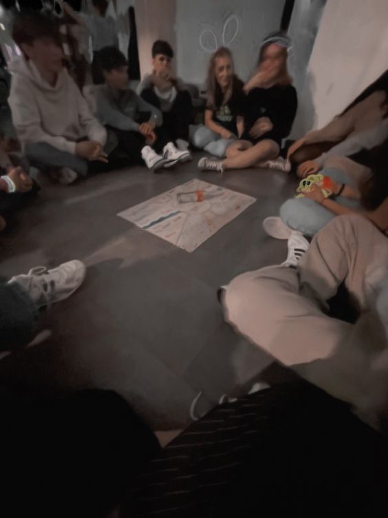 a group of people sitting around each other on the floor in a room with white walls