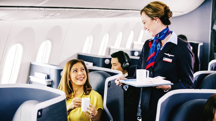 an air plane with people sitting on seats and one woman holding a cup in her hand