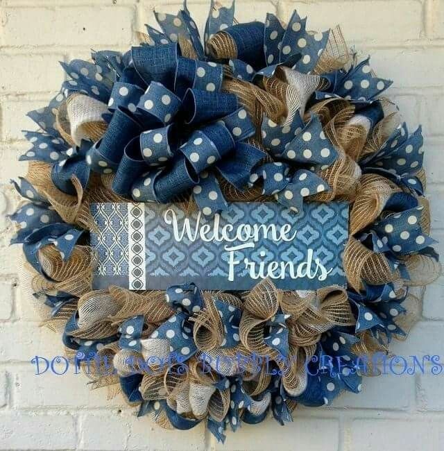 a welcome friends wreath hanging on the side of a brick wall with blue and white polka dots