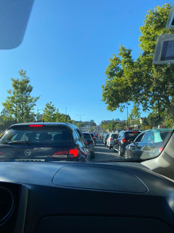 cars are parked on the side of the road in front of some trees and buildings