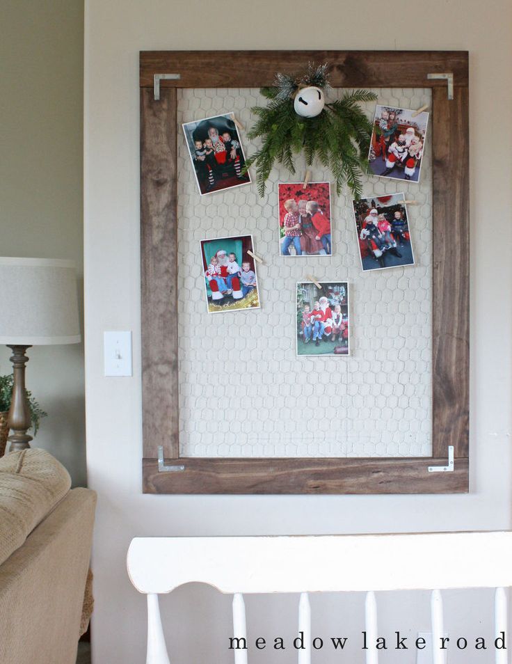 a wooden frame hanging on the wall next to a white bench with pictures pinned to it