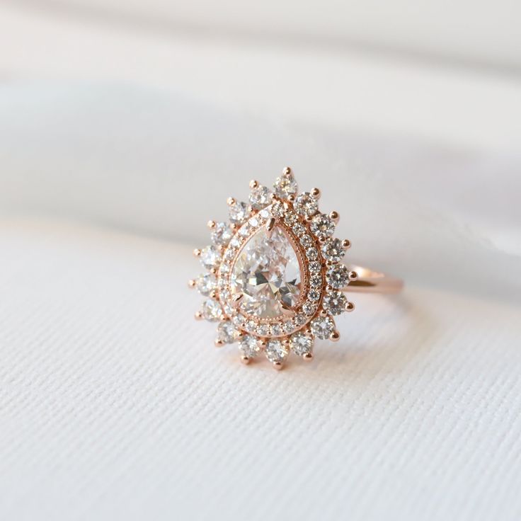 a diamond ring sitting on top of a white cloth