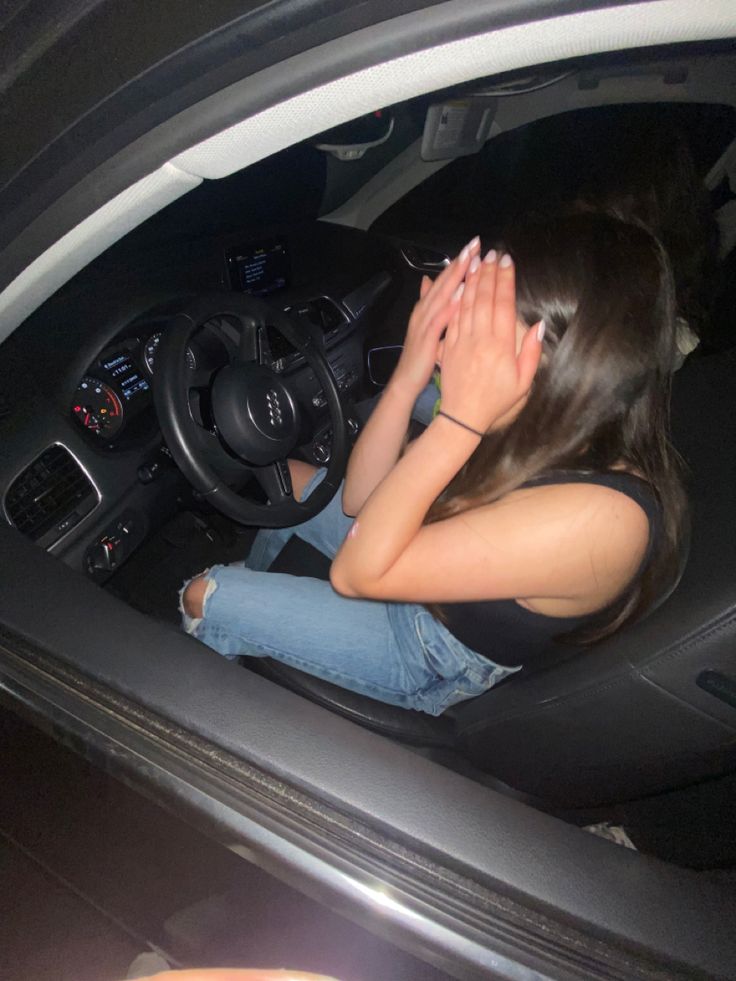 a woman sitting in the driver's seat of a car