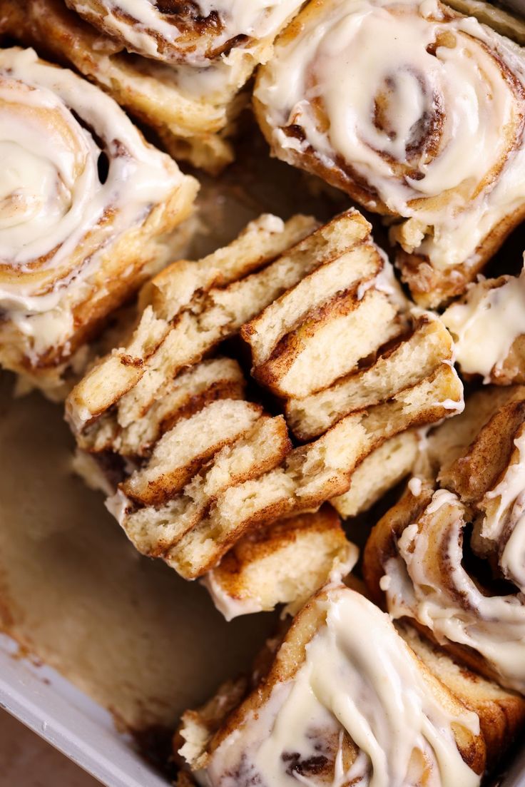 cinnamon rolls with icing sitting in a pan