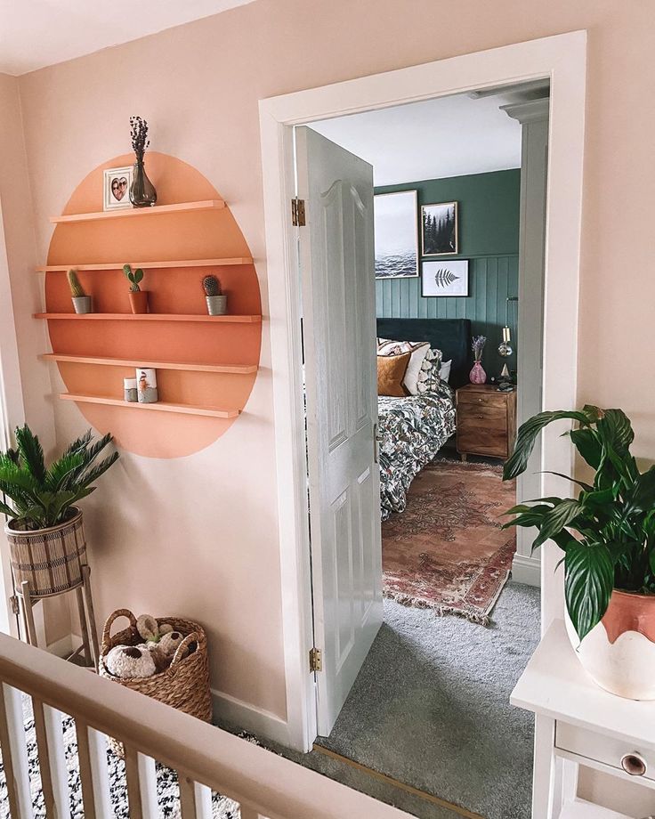 an entry way leading to a bedroom with pink walls and white railings on either side