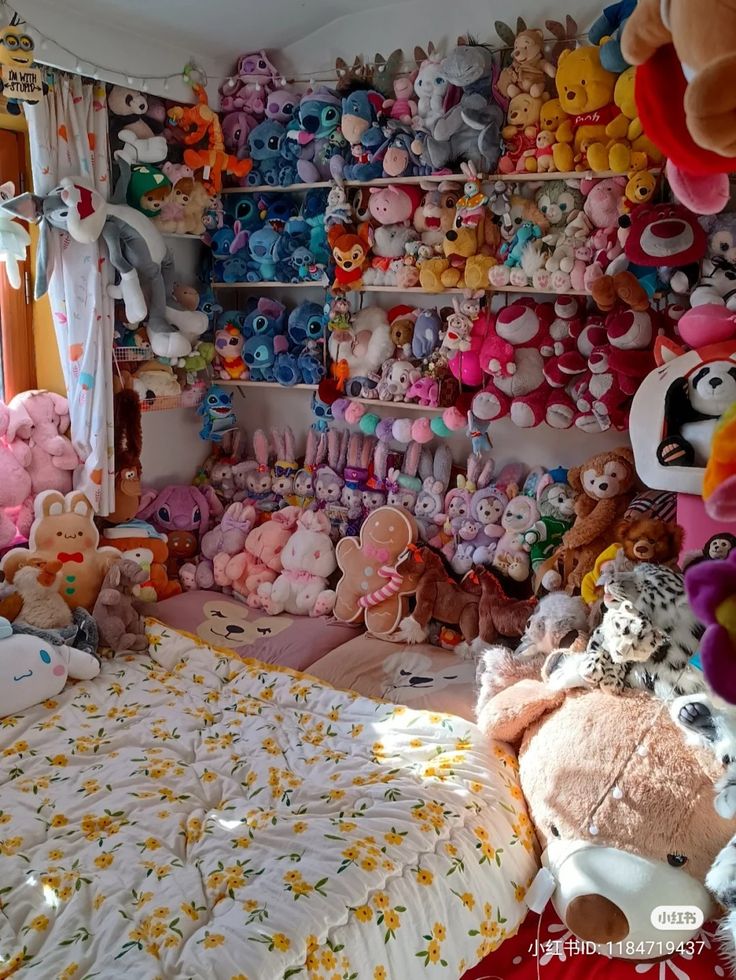 a room filled with lots of stuffed animals next to a bed covered in white sheets