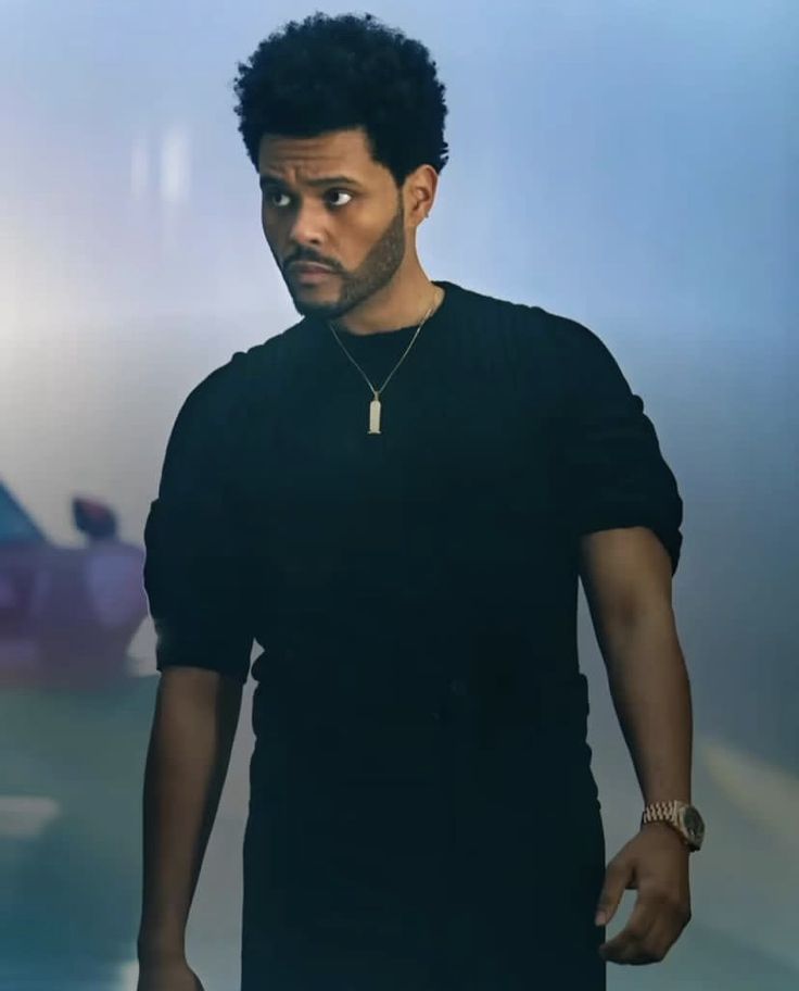 a man in black shirt standing next to a car