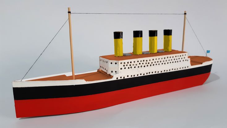 a paper model of a boat with three yellow cylinders on the front and two black ones on the back