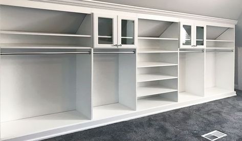 an empty room with white shelves and carpet