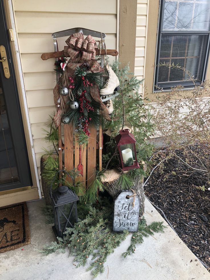 a wooden sled with christmas decorations on the front porch next to a house door