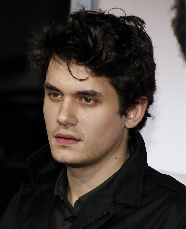 a close up of a person wearing a black shirt and looking off to the side