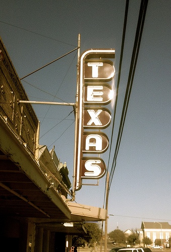 a sign that reads tex's on the side of a building next to a street