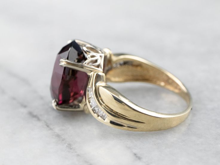 This vintage yellow gold bypass style mounting has simple baguette diamonds sweeping shoulders on the sides and secure prongs. We've set this piece with a deep red garnet. The color of this stone is deeper, a rich, crimson-cranberry hue. This would make a lovely cocktail ring, and is also a sturdy enough stone to wear every day! Metal: 14K Yellow Gold Gem: Garnet 9.03 Carats Gem Measurements: 11.0 x 13.8 mm, Oval Accents: 14 Diamonds totaling .28 Carats, H in Color, SI in Clarity Ring Size: 6.75 Gold Garnet Ring, Yellow Gold Sapphire Ring, Right Hand Ring, Diamond Cocktail Ring, Garnet Gem, Cameo Ring, Baguette Diamonds, Right Hand Rings, Hand Ring