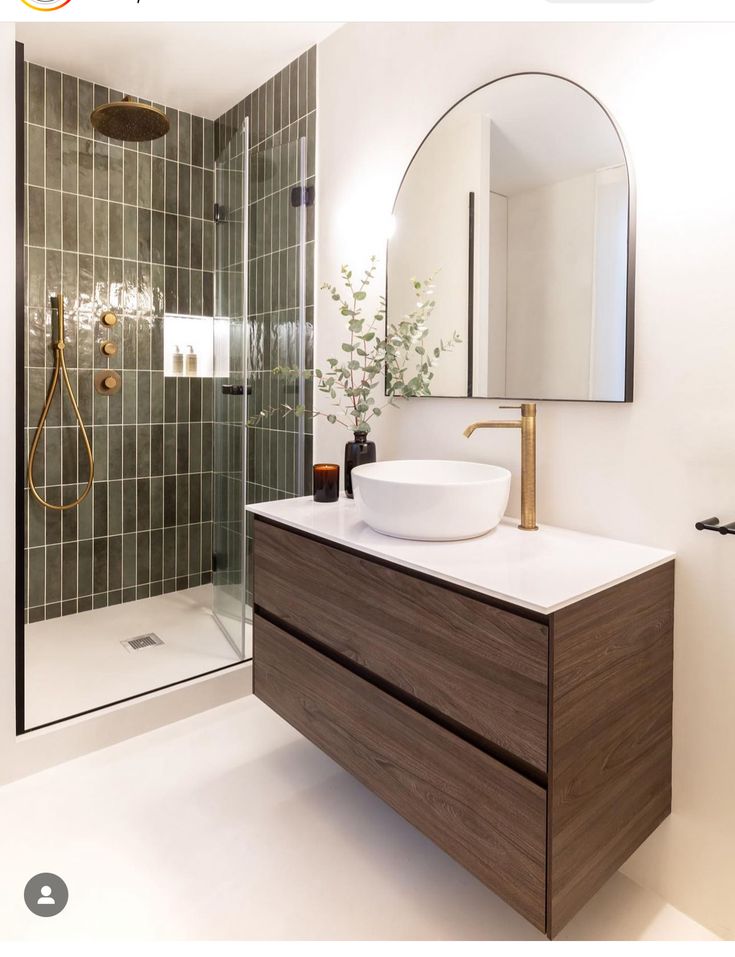 a bathroom with a sink, mirror and shower stall in it's own home