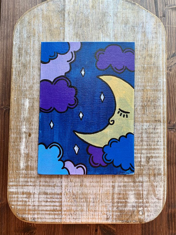 a painting of a moon and clouds on a wooden surface