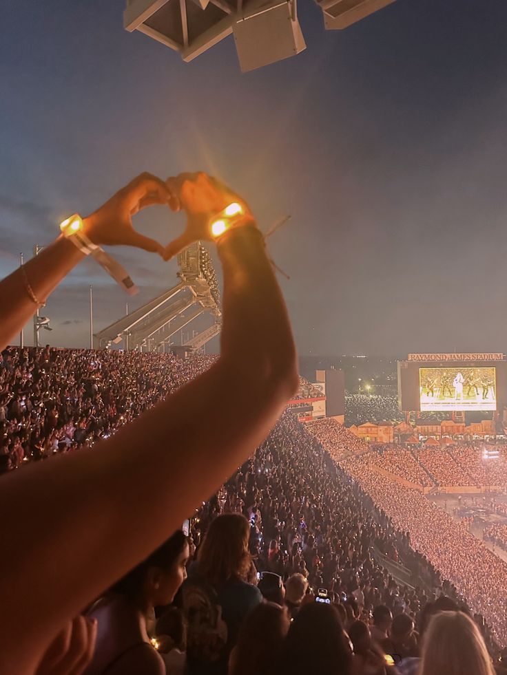 a person holding up their cell phone at a concert