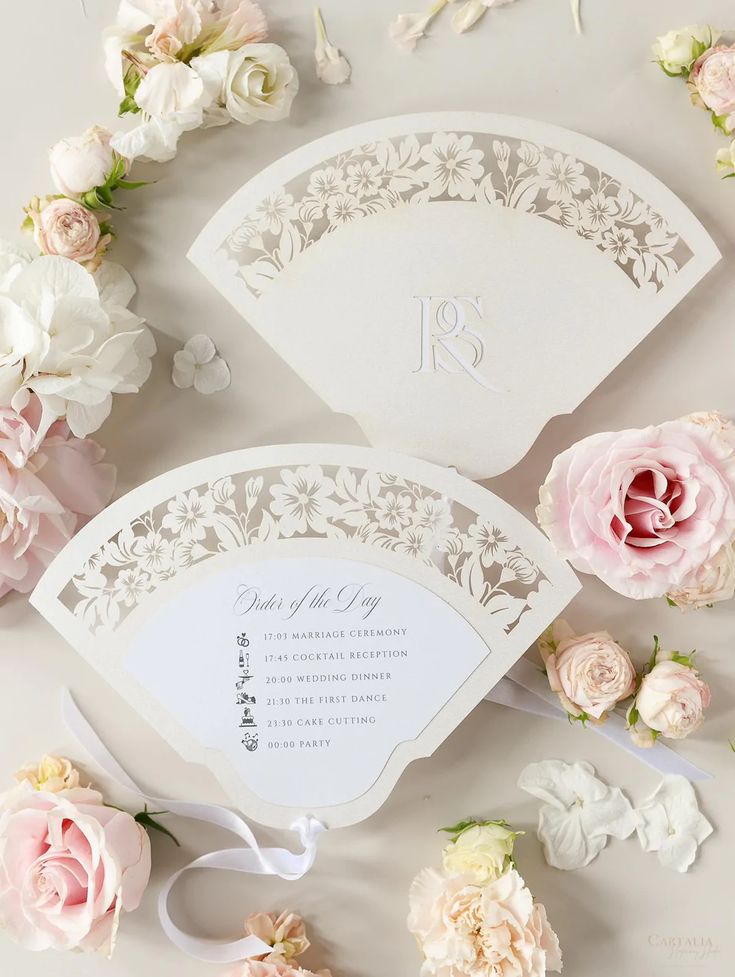 the wedding stationery is surrounded by flowers