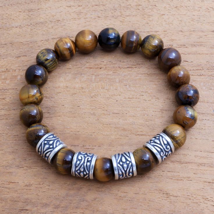 Designed for men by Balinese artisan Asmara Putra this stretch bracelet circles the wrist with beads of natural tiger's eye. At the front of the bracelet the tiger's eye alternates with four sterling silver beads that feature intricate patterns. Handmade Bracelets For Men, Jewelry Workshop, Tiger Eye Beads, Mens Beaded Bracelets, African Beads, Bracelet Crafts, Tiger's Eye, Beaded Necklaces, Beaded Stretch Bracelet