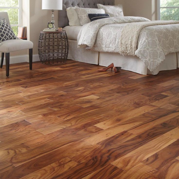 a bedroom with wood floors and white bedding