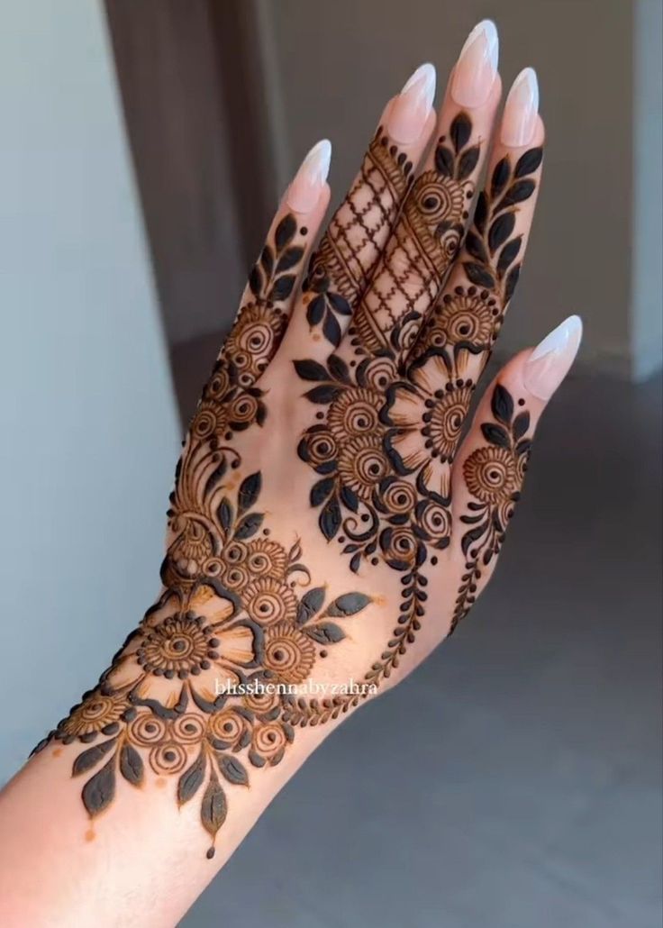 a woman's hand is decorated with hennap and intricate designs on it