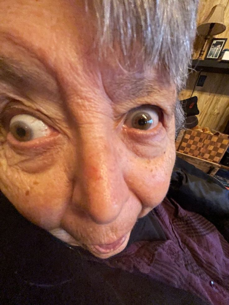 an old woman with big eyes looking at the camera