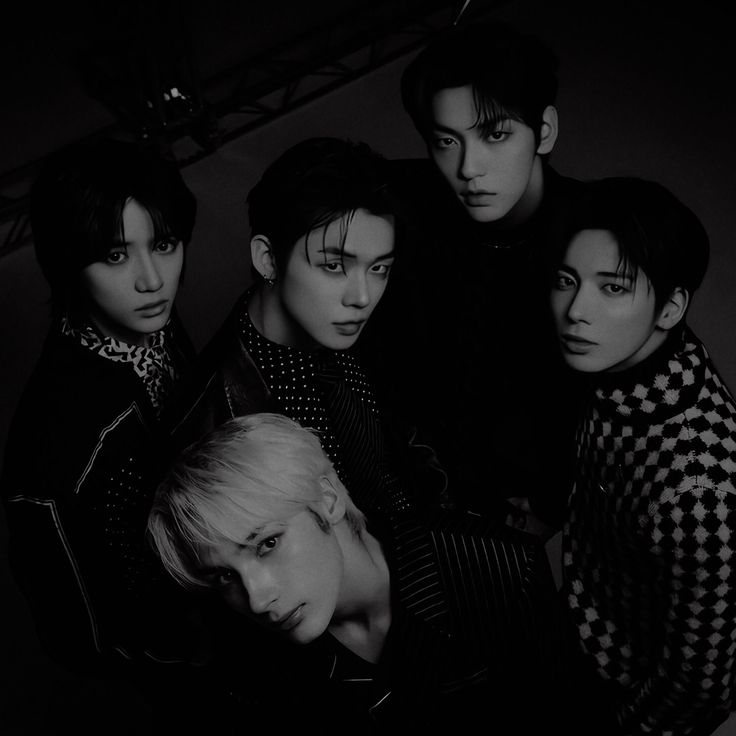 black and white photo of group of young men with one woman's head resting on her shoulder