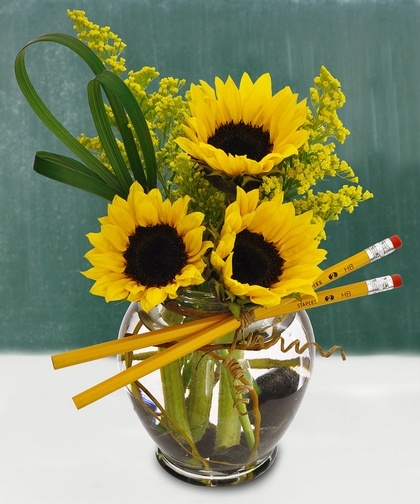 a vase filled with yellow flowers and pencils