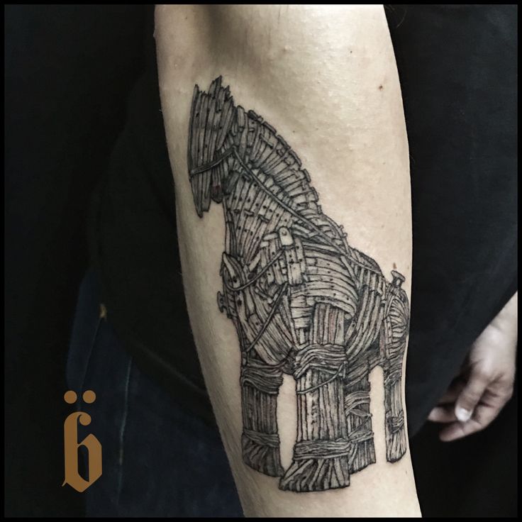 a man's arm with a horse made out of books and pencils on it