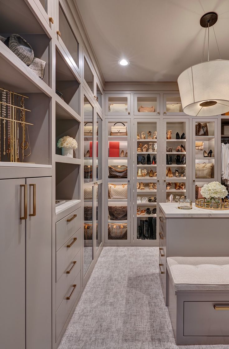 a walk in closet with lots of shelves and drawers