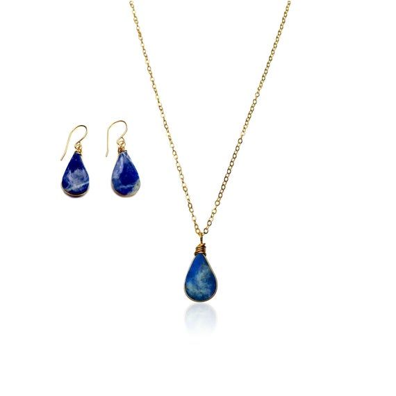 SODALITE JEWELRY SETThis delicate, teardrop Sodalite jewelry set is the epitome of understated beauty, making it the perfect gift for women any day of the year.The dainty necklace and earrings set is comprised of genuine indigo blue Sodalite stones. Choose either Sterling Silver 925 or 14K Gold fill as your finish. Also choose your chain length: 16 inches, 18 inches or 20 inches.The small and lightweight Sodalite stones are set in a lovely teardrop shape and are expertly wire wrapped by hand. Pl Blue Drop Jewelry With Natural Stones, Blue Teardrop Pendant Jewelry With Natural Stones, Blue Teardrop Pendant With Natural Stones, Sapphire Teardrop Jewelry With Natural Stones, Teardrop Sapphire Jewelry With Natural Stones, Blue Lapis Lazuli Teardrop Jewelry, Blue Teardrop Lapis Lazuli Jewelry, Blue Teardrop Necklace With Matching Earrings, Minimalist Blue Teardrop Jewelry