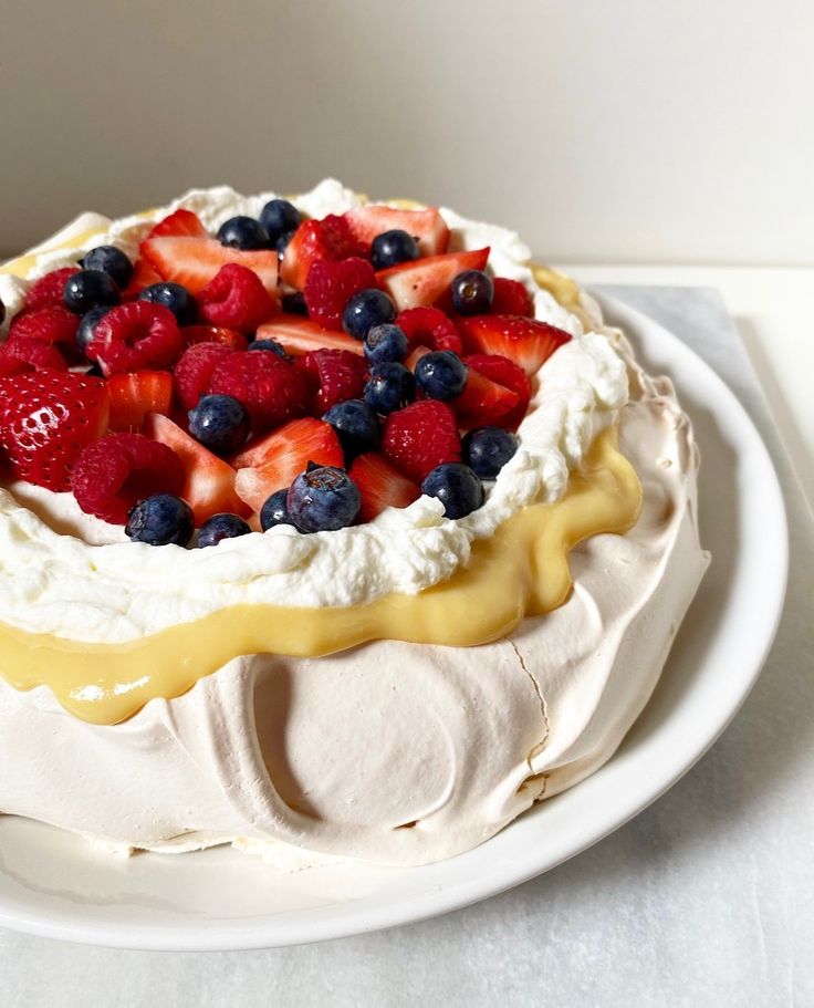 a cake with fruit on top sitting on a white plate