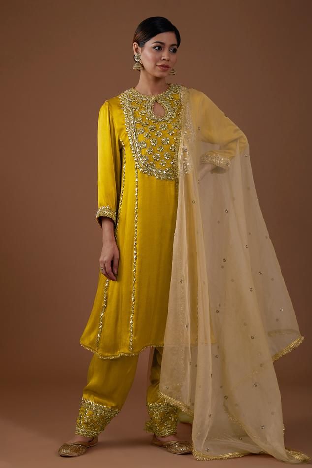 Gold saffron kurta with gota, sparkling sequin, lustrous pearl, nakshi embellishment on yoke. Paired with pleated salwar and desert sand dupatta.
Components: 3
Pattern: Embellishment
Type Of Work: Gota, sequin, pearl, nakshi
Neckline: Keyhole
Sleeve Type: Long sleeves
Fabric: Kurta and Salwar: Mashru Silk, Dupatta: Organza
Color: Gold
Other Details: 
Fringe border
Contrast dupatta
Embroidery on salwar hem
Model height: 5ft 7inches, wearing size M
Occasion: Sangeet - Aza Fashions Women Kurta, Silk Bottoms, Embroidered Pants, Embroidered Neckline, Indian Fashion Designers, Kurta With Pants, Silk Dupatta, Boutique Fashion, Silk Pants